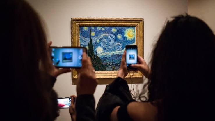 Museum visitors photographing Van Gogh&rsquo;s The Starry Night with their smartphones
